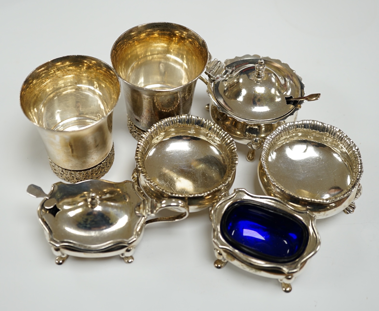 A modern pair of silver tots and five assorted silver condiments.